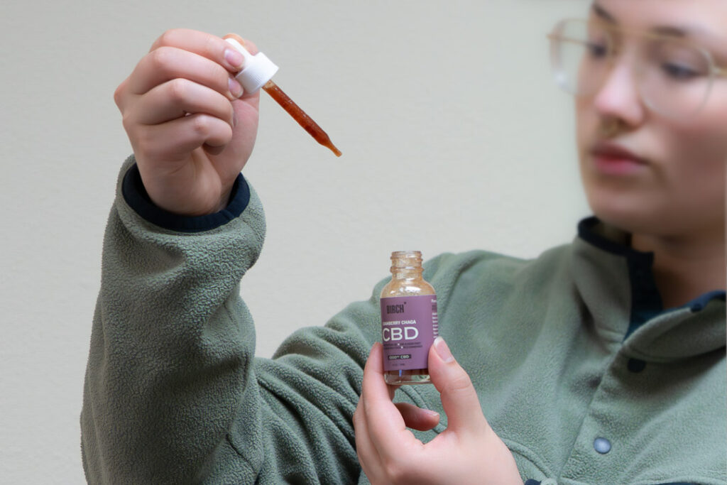 A woman using a local Alaska CBD tincture